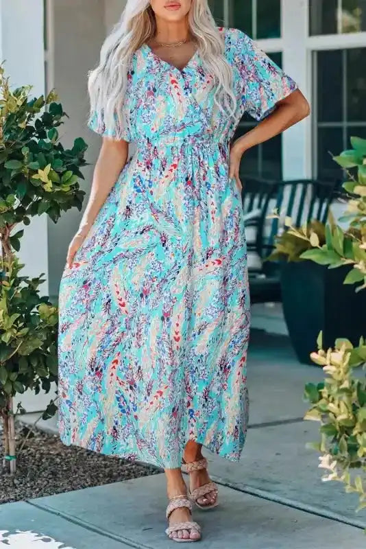 Green floral wrap maxi dress with V-neck and short sleeves, styled casually with sandals for a laid-back summer outfit.