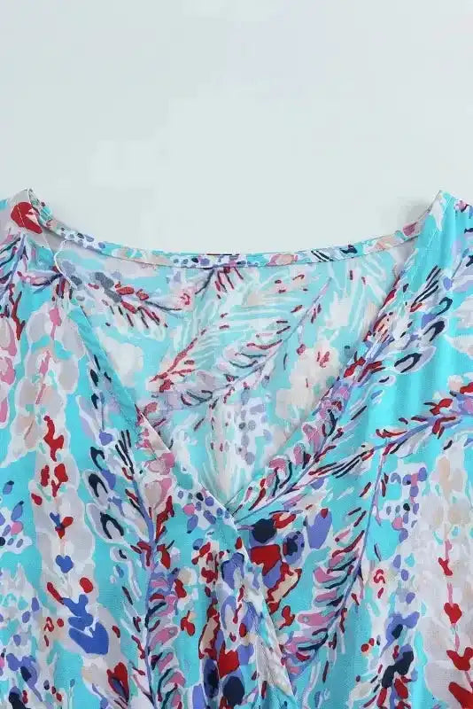 Close-up of V-neckline on green floral wrap maxi dress, showcasing the lightweight fabric and detailed abstract print.