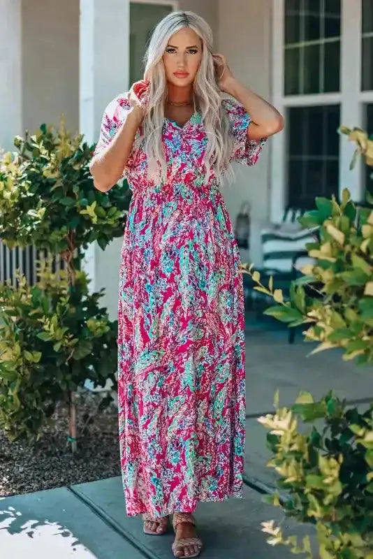 Model wearing pink floral wrap maxi dress with v-neck, styled with sandals for a relaxed summer outfit.