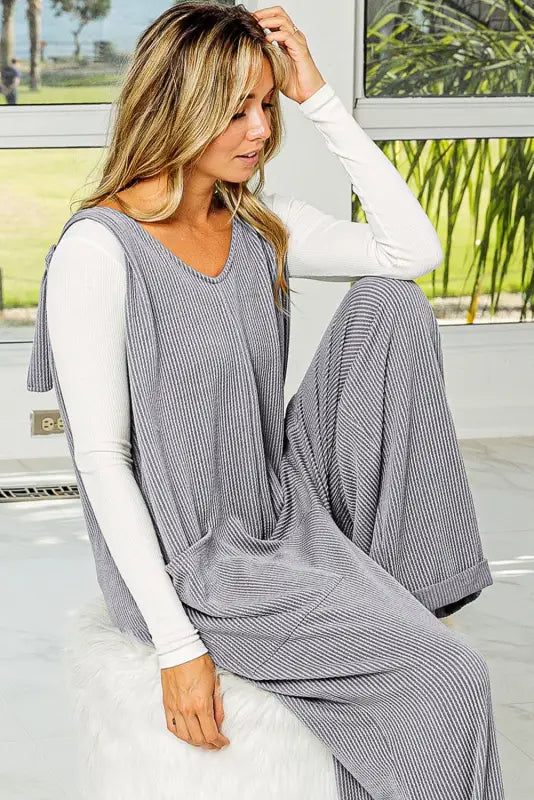 Woman in a grey corded wide leg jumpsuit and white undershirt, relax relax stylish look