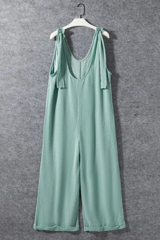 Wide leg mint green ribbed jumpsuit with shoulder ties hanging on a white hanger