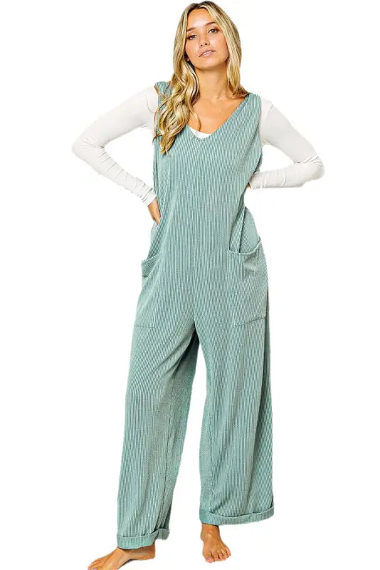 Wide leg, mint green corduroy overalls over a white shirt provide a relaxed, stylish look