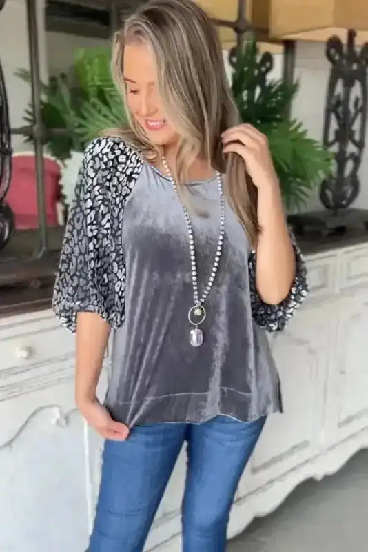 Luxurious Grey Leopard Velvet Blouse styled with jeans, showcasing elegant velvet texture and spliced leopard print sleeves for bold daily wear.