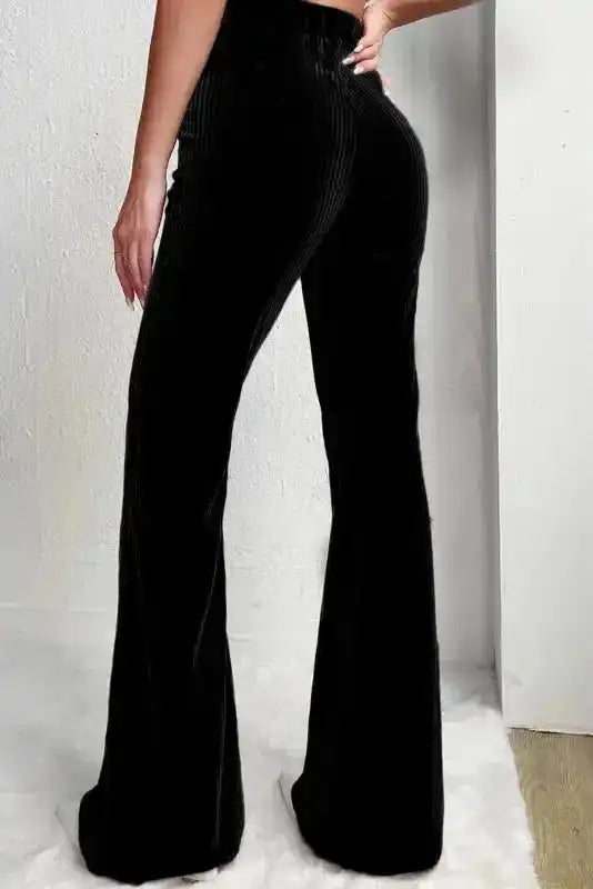 Back view of black flare corduroy pants for women, featuring a high waist and flattering silhouette for chic winter style.