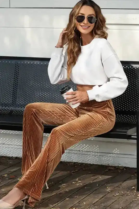High waist flare corduroy pants for women in brown, paired with a white sweatshirt, ideal for cozy winter outings and casual wear.