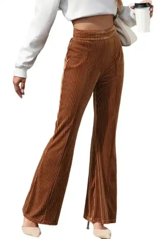 Women's high waist brown corduroy pants with flared legs, styled with a white crop sweatshirt for a trendy casual look.