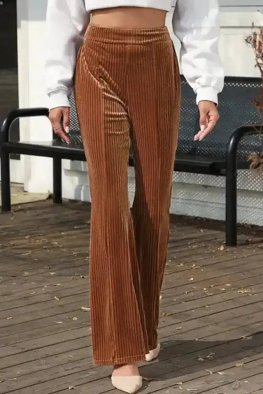 Front outdoor view of women's high waist flare corduroy pants in solid brown, perfect for casual and modern winter fashion.