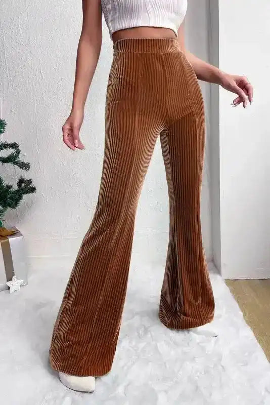 Side view of women's high waist flare corduroy pants in brown, featuring a soft ribbed texture and modern wide leg cut.