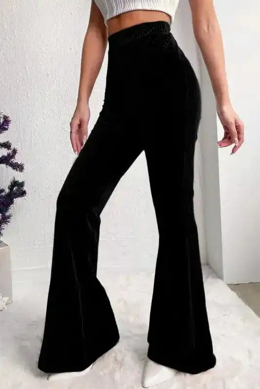 Side view of women's black high waist corduroy pants with flared legs, ideal for modern winter fashion and lounge wear.