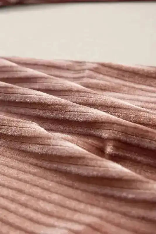 Macro shot of ribbed corduroy fabric used in women's flare pants, showcasing soft texture and winter-appropriate material.