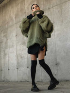 Olive green fluffy chunky knit turtleneck jumper styled with black mini dress and thigh-high socks, a bold fall fashion look.