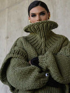 Close-up of olive green fluffy chunky knit turtleneck jumper highlighting thick ribbed texture and oversized collar.