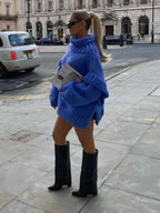 Blue fluffy chunky knit turtleneck jumper styled with black boots, ideal for bold and cozy winter street fashion.