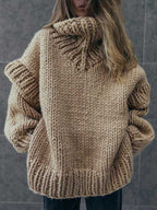 Beige fluffy chunky knit turtleneck jumper shown from the back, highlighting its thick texture and oversized fit.