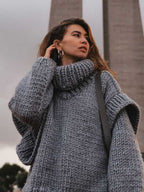 Gray fluffy chunky knit turtleneck jumper worn outdoors, styled with hoop earrings for a cozy fall fashion vibe.