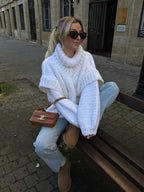 White fluffy chunky knit turtleneck jumper styled with jeans and a brown crossbody bag, perfect for casual fall days.