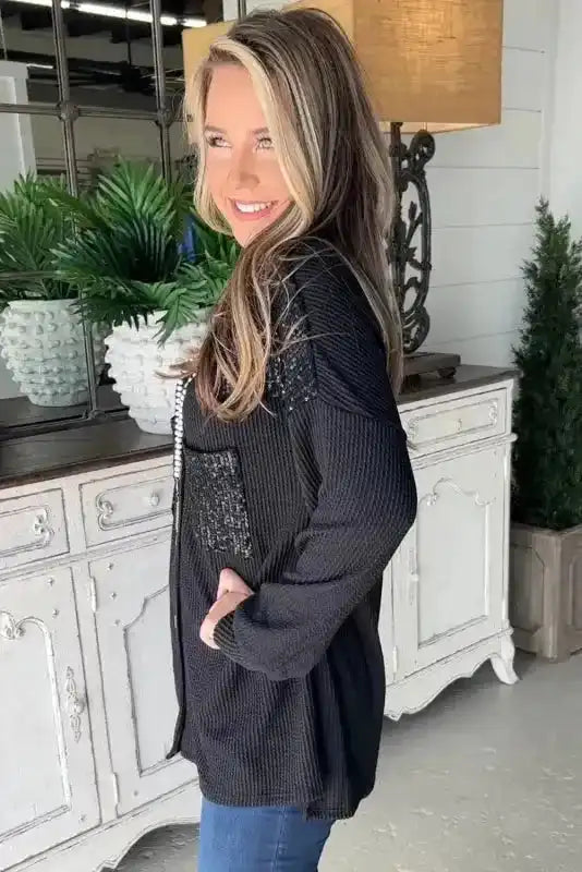 Side view of Black Sequin Patch Corded Shacket Overshirt for women, showing relaxed fit and textured ribbed fabric for winter fashion.