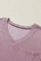 Close-up of V-neckline on mauve pink corded T-shirt, showcasing ribbed texture and soft fabric for a comfortable, relaxed fit.