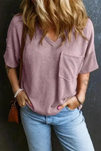 Women's corded V-neck loose T-shirt in mauve pink with chest pocket, styled with jeans for a soft, casual everyday outfit.
