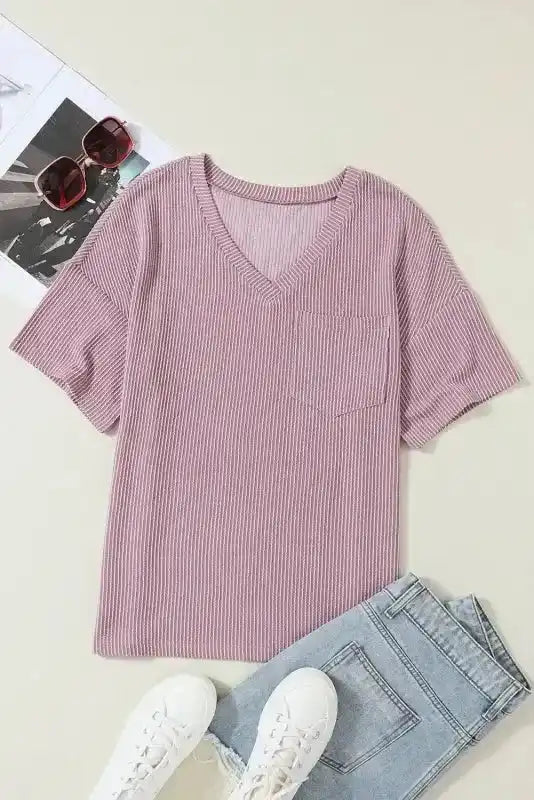 Flat lay of mauve pink corded V-neck T-shirt with chest pocket, paired with jeans and sneakers, ideal for casual women’s fashion.
