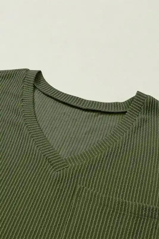 Close-up of V-neckline on olive green corded T-shirt, highlighting ribbed fabric texture and soft, breathable material for daily comfort.