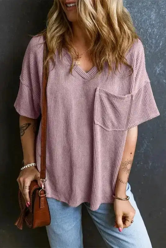 Front view of mauve pink corded V-neck T-shirt with chest pocket, styled casually with accessories and light denim for daily wear.