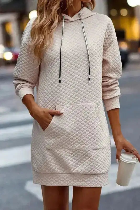 Model wearing Quilted Hooded Dress - Kangaroo Pocket with coffee cup, showcasing cozy fit and casual silhouette.