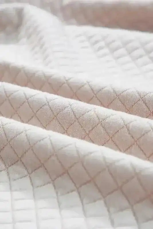 Fabric close-up of Quilted Hooded Dress - Kangaroo Pocket, showing diamond quilt pattern and soft material.