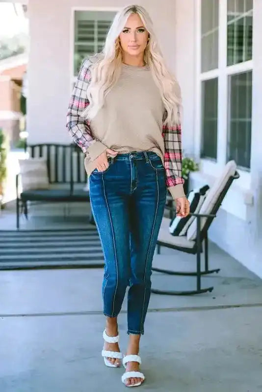 Full body view of quilted hooded dress with plaid sleeves, paired with jeans and sandals for a stylish daily outfit.