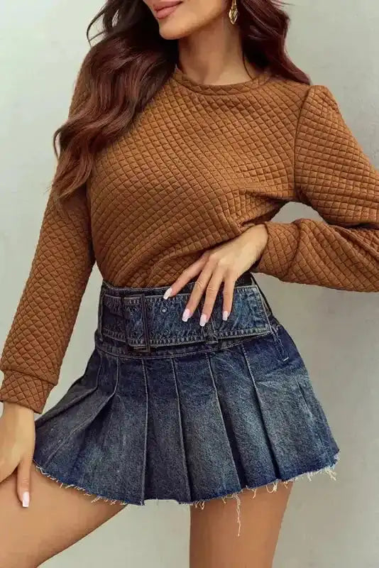 Camel brown quilted hooded dress styled with frayed hem pleated denim skirt, emphasizing modern casual fashion and comfort.