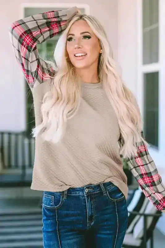 Woman wearing quilted hooded dress with plaid sleeves, highlighting the soft texture and relaxed fit for casual outings.