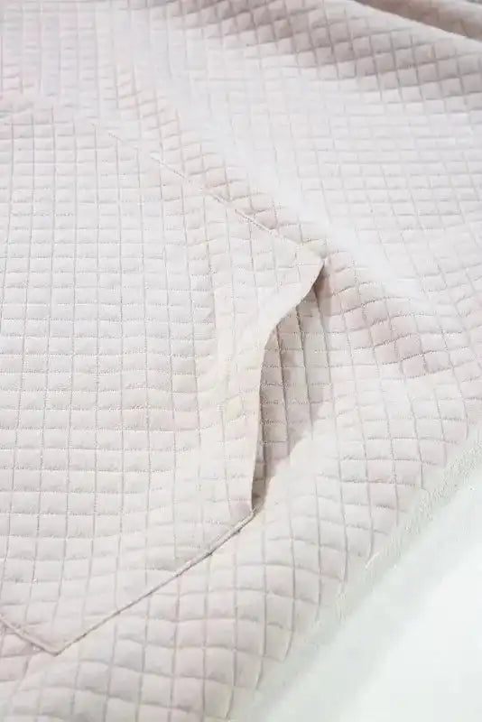 Close-up of kangaroo pocket on Quilted Hooded Dress, showcasing functional design and quilted fabric.