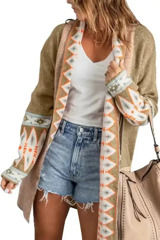 Model in Khaki Aztec Knit Duster Cardigan paired with denim shorts and white top, showcasing tribal print and relaxed fit.