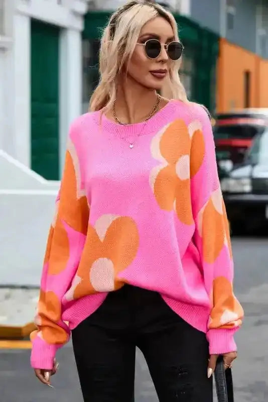 Relaxed fit Khaki Floral Drop Shoulder Sweater in pink and orange floral print, styled with black distressed jeans for versatile everyday wear.
