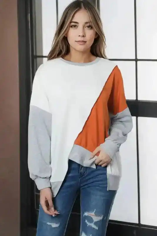 Minimalist styling of Khaki Colorblock Stitching Irregular Hem Long Sleeve Top paired with distressed jeans for a laid-back look.