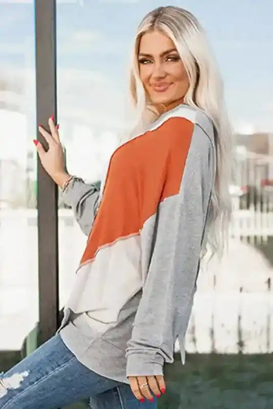 Side angle of Khaki Colorblock Stitching Irregular Hem Long Sleeve Top highlighting the bold rust and gray colorblock design.
