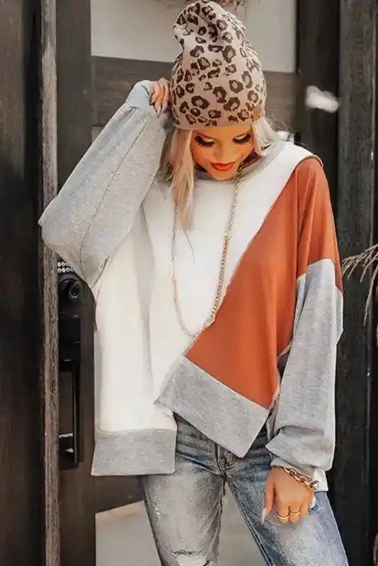 Fall-ready Khaki Colorblock Stitching Irregular Hem Long Sleeve Top styled with ripped jeans and a cozy beanie for a casual look.