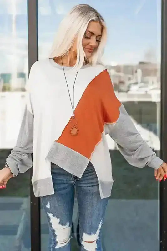 Front view of Khaki Colorblock Long Sleeve Top with asymmetrical hem and relaxed fit, styled with jeans for a casual outfit.