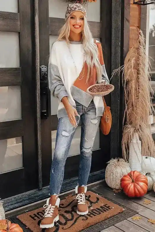 Full outfit view of Khaki Colorblock Stitching Irregular Hem Long Sleeve Top paired with jeans, boots, and fall decor for seasonal styling.