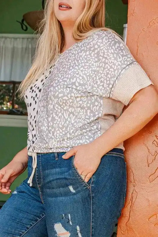 Side angle of Khaki Plus Size Leopard Print Colorblock V Neck T Shirt showing mixed leopard prints and ribbed sleeve cuffs.