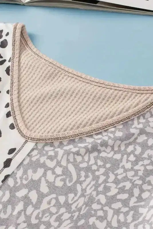 Close-up of V neckline on Khaki Plus Size Leopard Print Colorblock V Neck T Shirt with ribbed trim and dual print design.