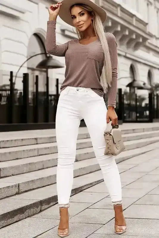 Full outfit featuring khaki V-neck knit top with ribbed texture and white skinny jeans, perfect for early fall fashion.