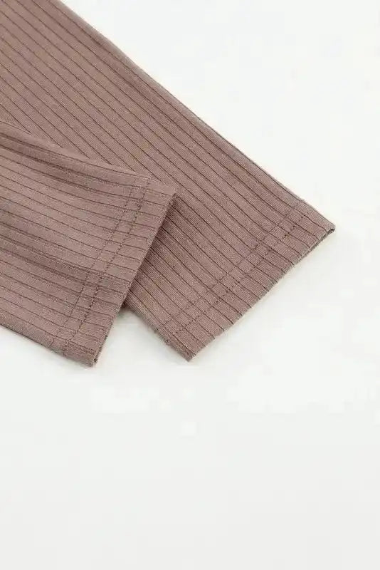 Sleeve hem detail of khaki ribbed knit top, showing fine stitching and soft elastic fabric.