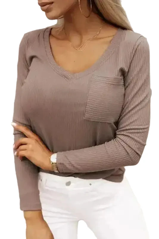 Khaki V-neck knit top with ribbed texture, long sleeves, and chest pocket styled with white jeans for a casual fall look.