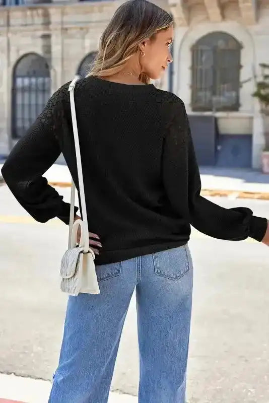 Rear view of Black Lace Sleeve Textured Top styled with light denim, showing lace shoulder design and soft knit texture.