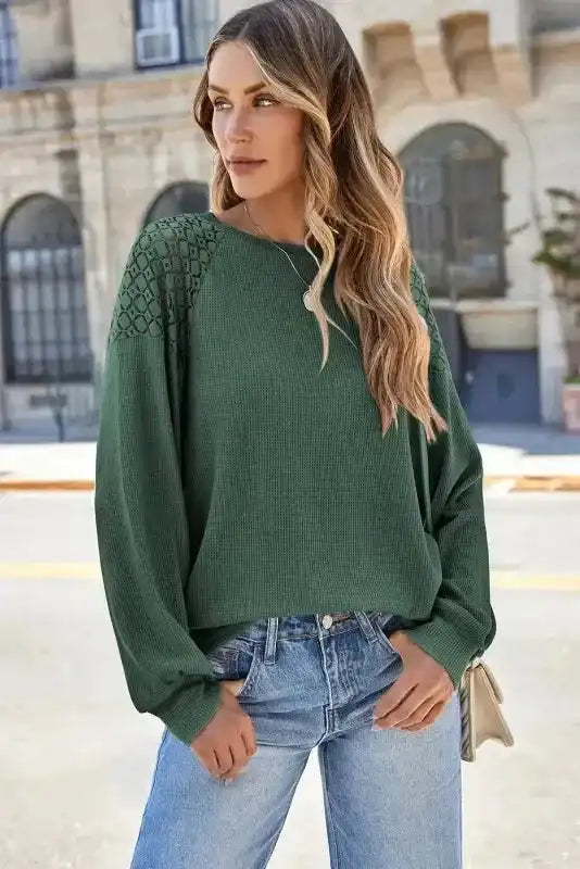 Front view of Lace Sleeve Textured Top in green, featuring lace shoulder panels and loose fit, styled with light blue jeans. Elegant fall women’s top.
