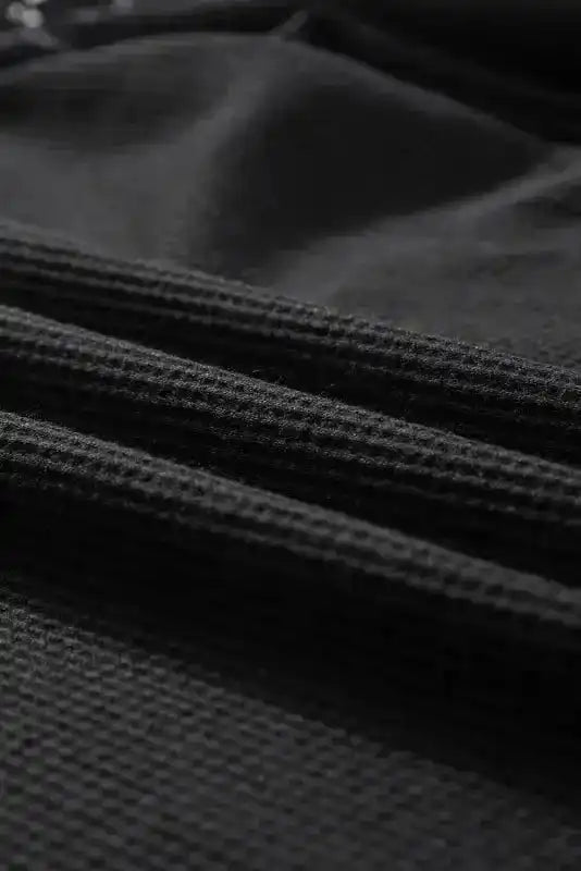 Close-up of ribbed fabric texture of Black Lace Sleeve Textured Top, ideal for fall and autumn wear.