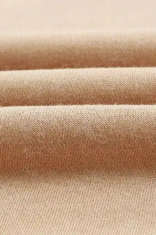 Front view of beige oversized bishop sleeve sweatshirt styled as a dress, offering a trendy and comfortable winter fashion option.