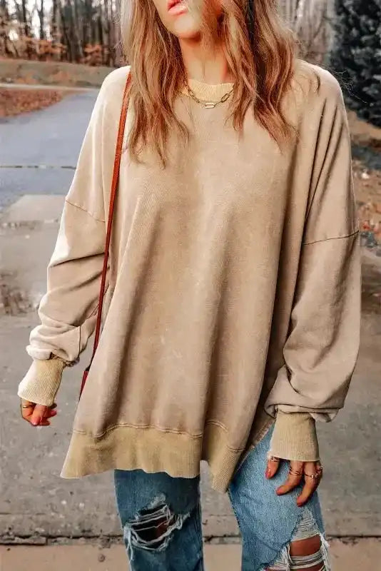 Beige oversized sweatshirt with bishop sleeves and ribbed cuffs, styled casually with ripped jeans for a cozy daily winter outfit.