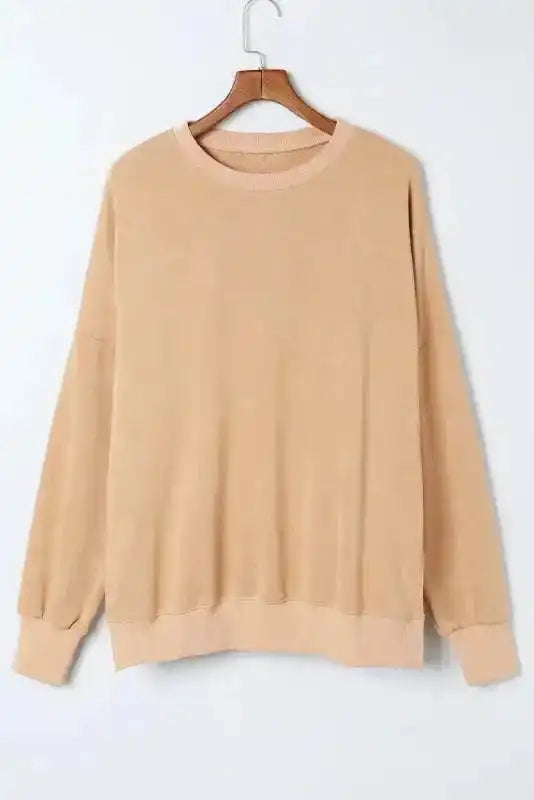 Flat lay of beige bishop sleeve sweatshirt on hanger, showing ribbed neckline and relaxed silhouette for versatile winter styling.